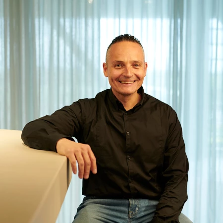 Giovanni, technický odpovědný pracovník společnosti Lamett, sedí u baru v showroomu.